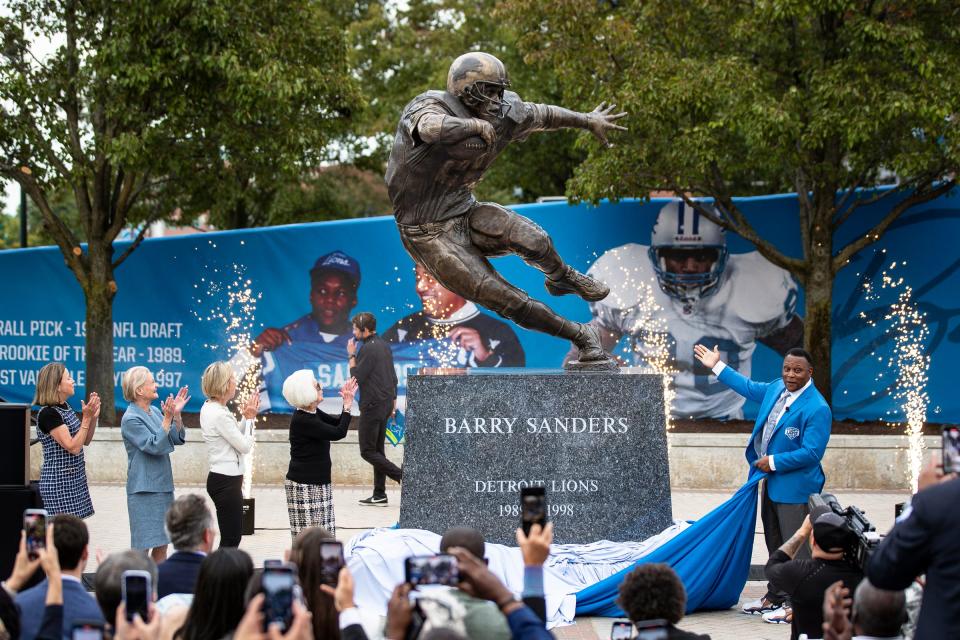 Barry Sanders, right, along with Detroit Lions owner and chair emeritus Martha Ford and principal owner and chair Sheila Ford Hamp unveil the statue outside of Ford Field in Detroit on Saturday, Sept. 16, 2023.