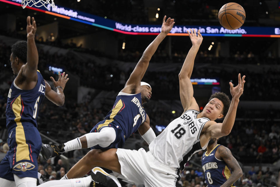 San Antonio Spurs' Isaiah Roby (18) collides with New Orleans Pelicans' Devonte' Graham (4) during the first half of an NBA basketball game, Wednesday, Nov. 23, 2022, in San Antonio. (AP Photo/Darren Abate)