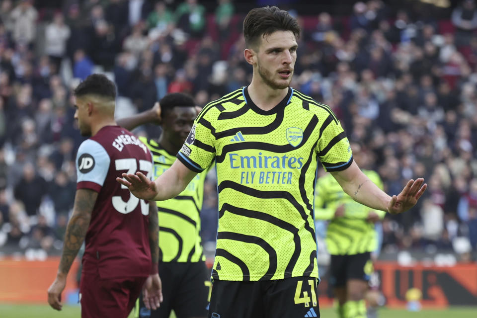 Arsenal's Declan Rice, puts his hands up, but does not celebrate after scoring his sides 6th goal against his former club, during the English Premier League soccer match between West Ham United and Arsenal at the London Stadium in London, Sunday, Feb. 11, 2024. (AP Photo/Ian Walton)