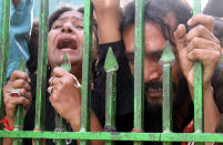 <p>Devotees stand outside the entrance gate of the shrine of Sufi Muslim Saint Lal Shahbaz Qalander a day after a suicide bomb attack at the site in Sehwan, Pakistan, Feb. 17, 2017. (Photo: Nadeem Khawer/EPA) </p>