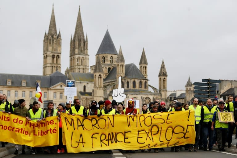 Yellow Vest protesters with a banner reading "Macron raises taxes, France explodes," in Caen, northwestern France