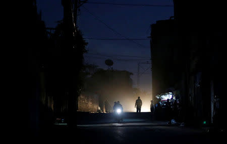 Palestinians ride a motorcycle during a power cut on a street in Beit Lahiya in the northern Gaza Strip. REUTERS/Mohammed Salem