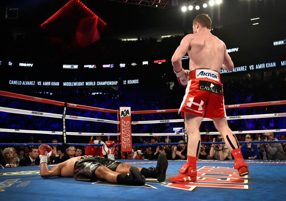 Canelo Alvarez stands over Amir Khan after delivering a knockout during the sixth round of their WBC middleweight title fight at T-Mobile Arena on May 7, 2016 in Las Vegas, Nevada. (Getty Images)