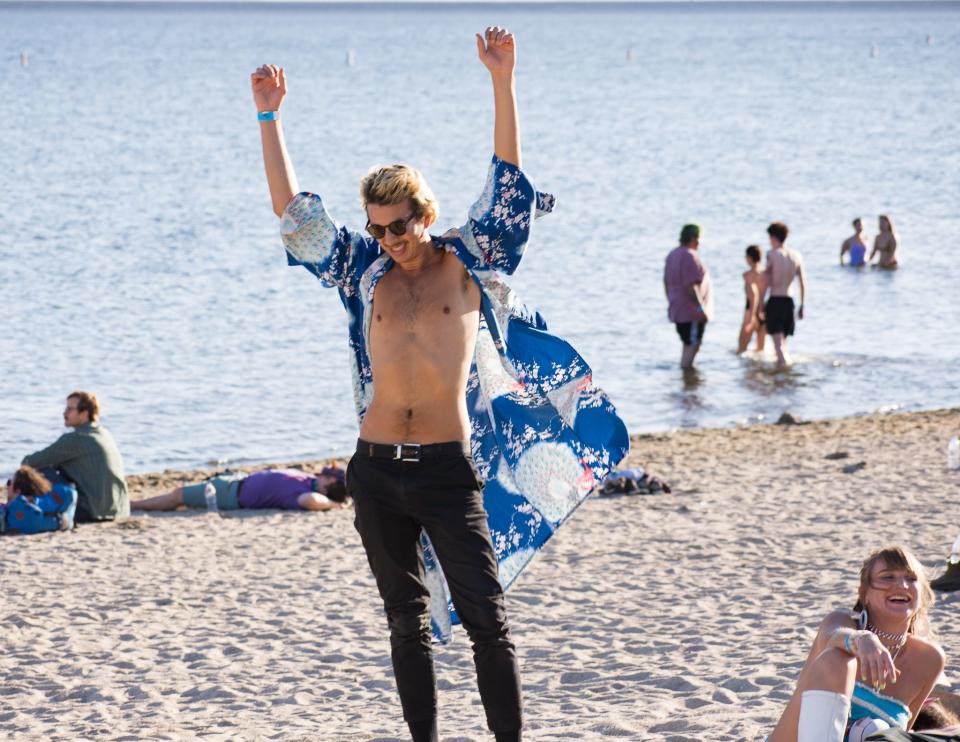 A man dances on the beach at Desert Daze at Moreno Beach in Lake Perris, Calif. on October 11, 2019