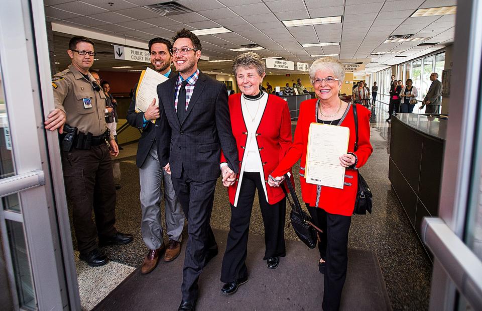 The first two couples to receive marriage licenses shortly after gay marriage was legalized in Arizona leave the Clerk of the Superior Court on Friday. October 17, 2014.  David Larance and Kevin Patterson were joined by  Nelda Majors  and Karen Bailey after getting the licenses.