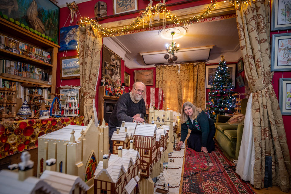 Mike Addis ,63 and wife Catherine Weightman, 58 with their lego display for this Christmas that is of Old London Bridge frost fair. Mike and Catherine from Huntingdon in Cambridgeshire  have been making lego displays for Christmas for 27 years ranging from well known buildings like Ely Cathedral festive characters like father christmas an angel and the three kings  and a lego Dalek.   See SWNS story SWCAlego. A Lego-mad couple have spent four weeks working 14 hours a day to create this stunning 21-foot-long replica of Old London Bridge in their own sitting room. Every year Mike Addis, 63, and Catherine Weightman, 58, build a massive Lego creation in time for Christmas. And their 27th project has just been completed using 400,000 Lego bricks. They have recreated Old London Bridge of 1400, one of several bridges which spanned the Thames at Southwark, including 78 houses, 500 mini-figures, a castle and chapel.  