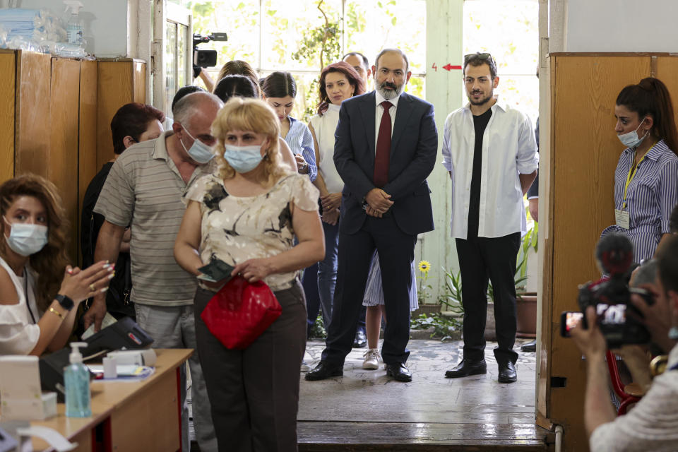 Acting Armenian Prime Minister Nikol Pashinyan, center, stands in line to vote at a polling station during a parliamentary elections in Yerevan, Armenia, Sunday, June 20, 2021. Armenians are voting in a national election after months of tensions over last year's defeat in fighting against Azerbaijan over the separatist region of Nagorno-Karabakh. (Tigran Mehrabyan/PAN Photo via AP)