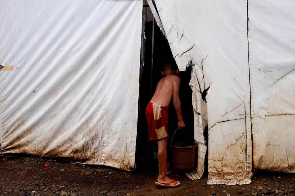 A boy carries a basin filled with water at an evacuation camp for families displaced by the Marawi siege, in Marawi City, Lanao del Sur province, Philippines. (Photo: Eloisa Lopez/Reuters)