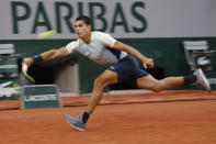 Spain's Carlos Alcaraz stretches to return the ball to Spain's Albert Ramos-Vinolas during their second round match of the French Open tennis tournament at the Roland Garros stadium Wednesday, May 25, 2022 in Paris. (AP Photo/Jean-Francois Badias)