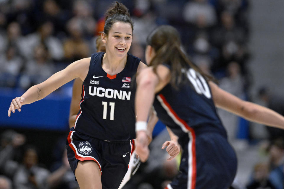 Connecticut's Lou Lopez-Senechal (11) celebrates with Connecticut's Nika Muhl during the second half of an NCAA college basketball game against North Carolina State, Sunday, Nov. 20, 2022, in Hartford, Conn. (AP Photo/Jessica Hill)