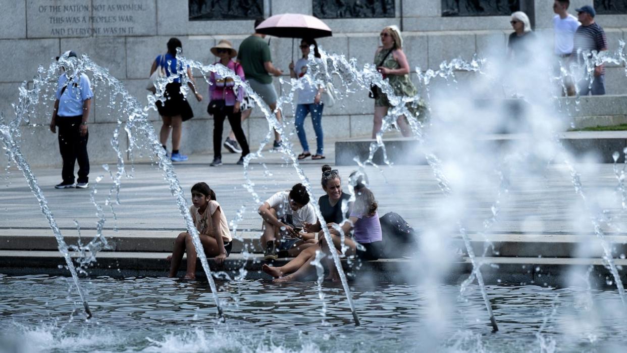 PHOTO: People rest their feet in a reflecting pool at the World War II Memorial on the National Mall, Aug. 28, 2024, in Washington. (Brendan Smialowski/AFP via Getty Images)