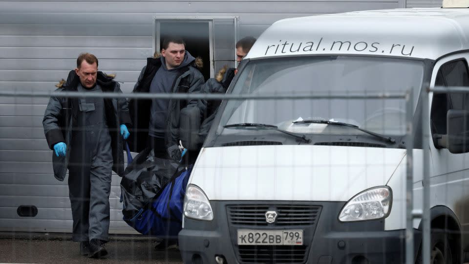 Specialists carry the body of a victim of the shooting attack. - Maxim Shemetov/Reuters