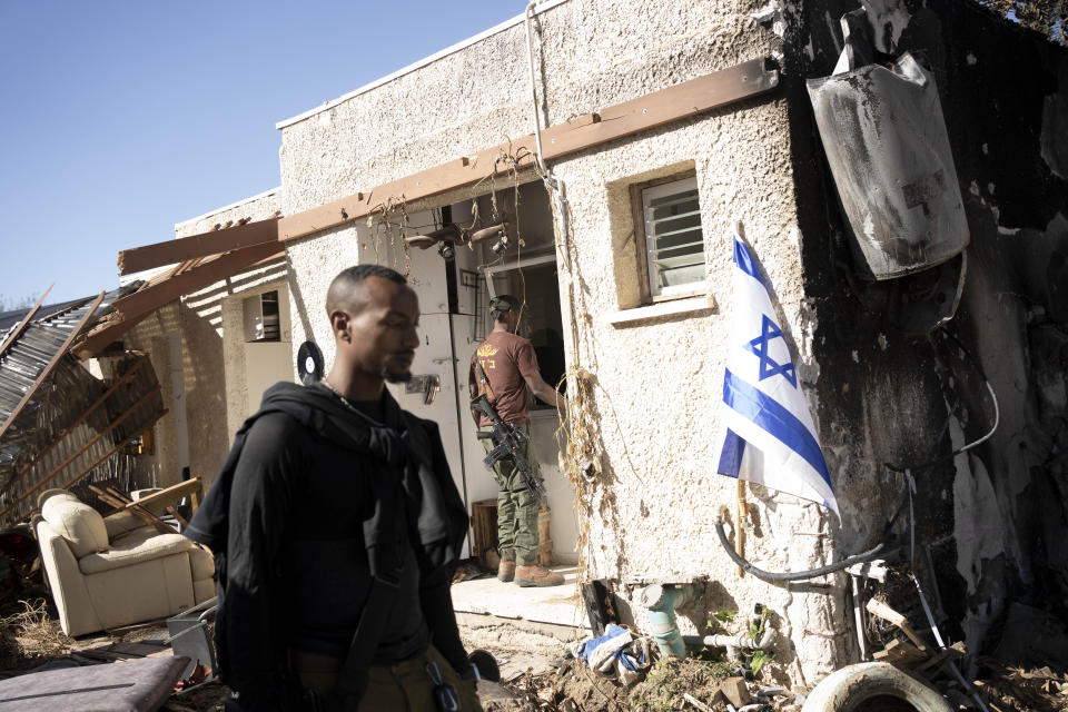 Israeli soldiers rest at Kibbutz Kfar Azza as Muslim, Jewish and Christian faith leaders tour ahead of an interfaith joint prayer near the Israel-Gaza border, the site of an Oct. 7 cross-border attack by Hamas that killed some 1,200 people and took more than 200 hostages, Wednesday, Nov. 29, 2023. (AP Photo/Maya Alleruzzo)