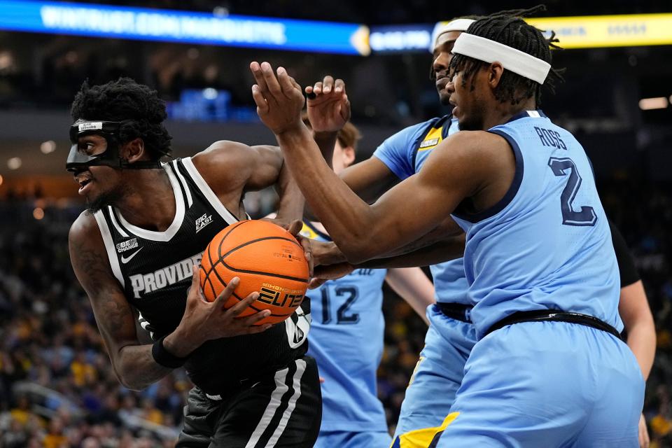 Providence guard Davonte Gaines drives to the basket against Marquette's Chase Ross during the first half Wednesday night in Milwaukee.