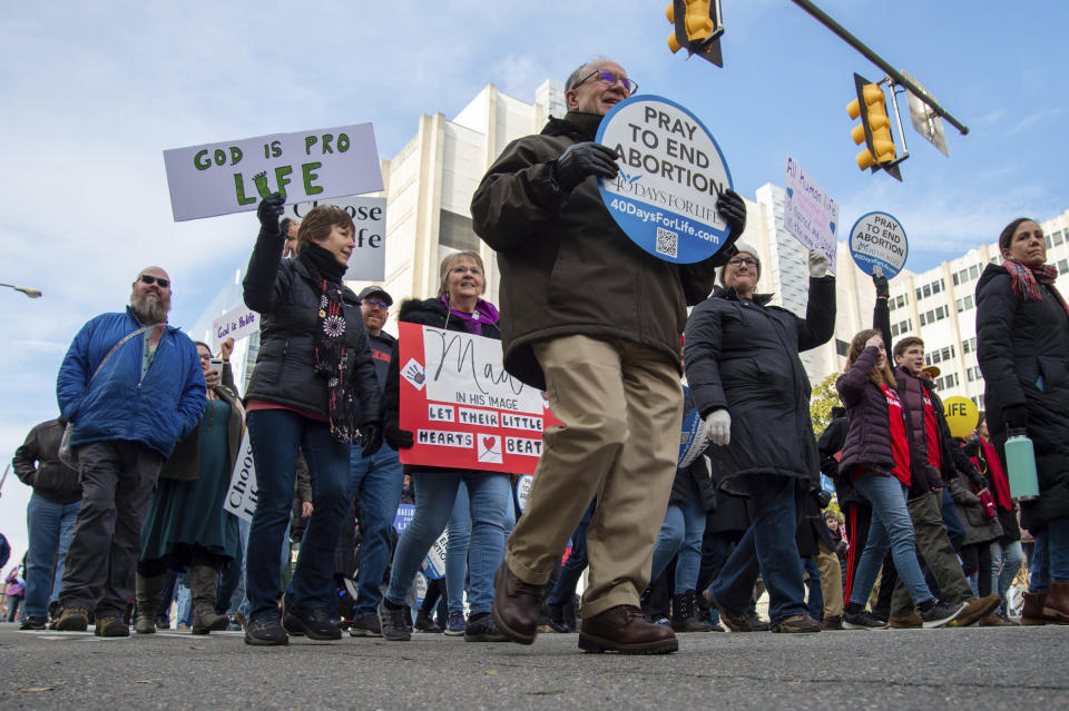 Attendees march and hold signs during the "March for Life" event on Wednesday, Feb. 1, 2023, in Richmond, Va. (AP Photo/Mike Caudill)