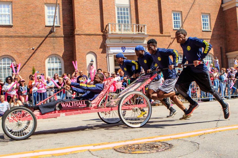 CLAY TEAGUE/FOR THE TELEGRAPH Macon, GA, 3/19/22 Members of the Macon-Bibb County Fire Department fly down Cherry Street and win the Bed Race Saturday during the 40th annual Cherry Blossom Festival.