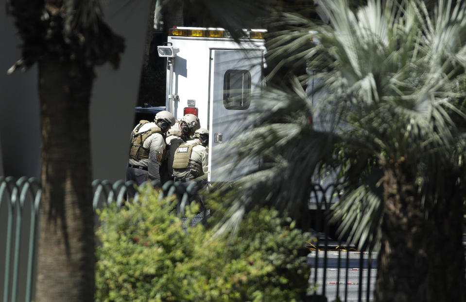 Police officers stand behind a truck along Las Vegas Boulevard, Saturday, March 25, 2017, in Las Vegas. Police say part of the Strip has been closed down after a shooting. (AP Photo/John Locher)