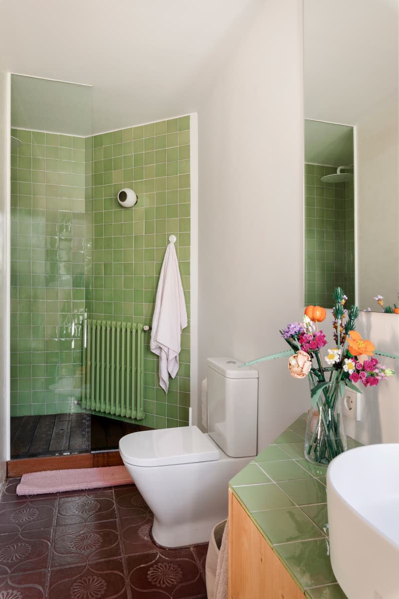 Pale green tiled bathroom.