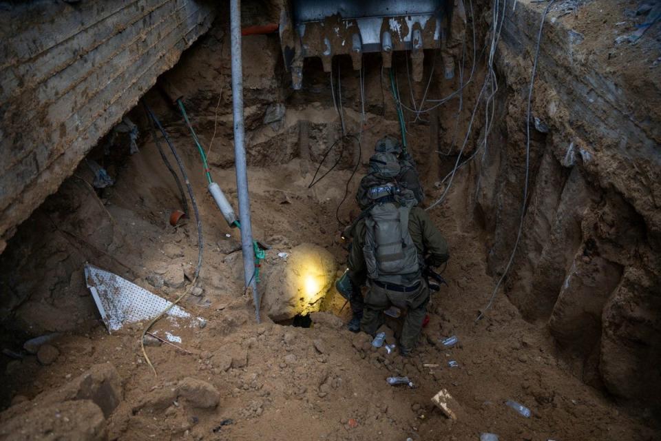 Israeli soldiers take position at what they say is a tunnel during the ongoing ground operation (via REUTERS)