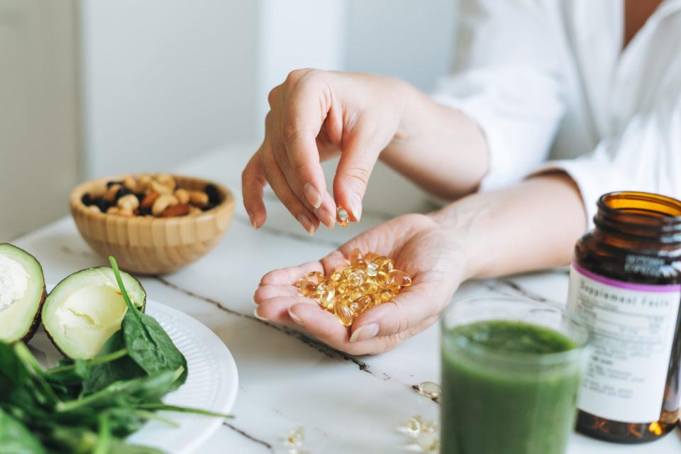 A hand holding multivitamin supplements.