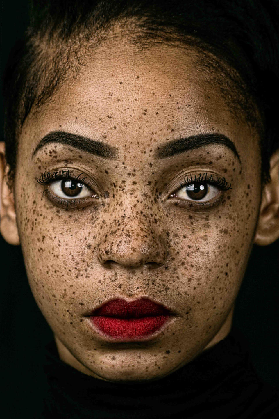 A portrait of a woman with freckles.