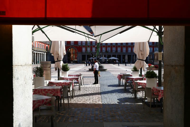 Un camarero con una mascarilla protectora espera a los clientes en una terraza de la Plaza Mayor en medio del brote de la enfermedad coronavirus (COVID-19) en Madrid.