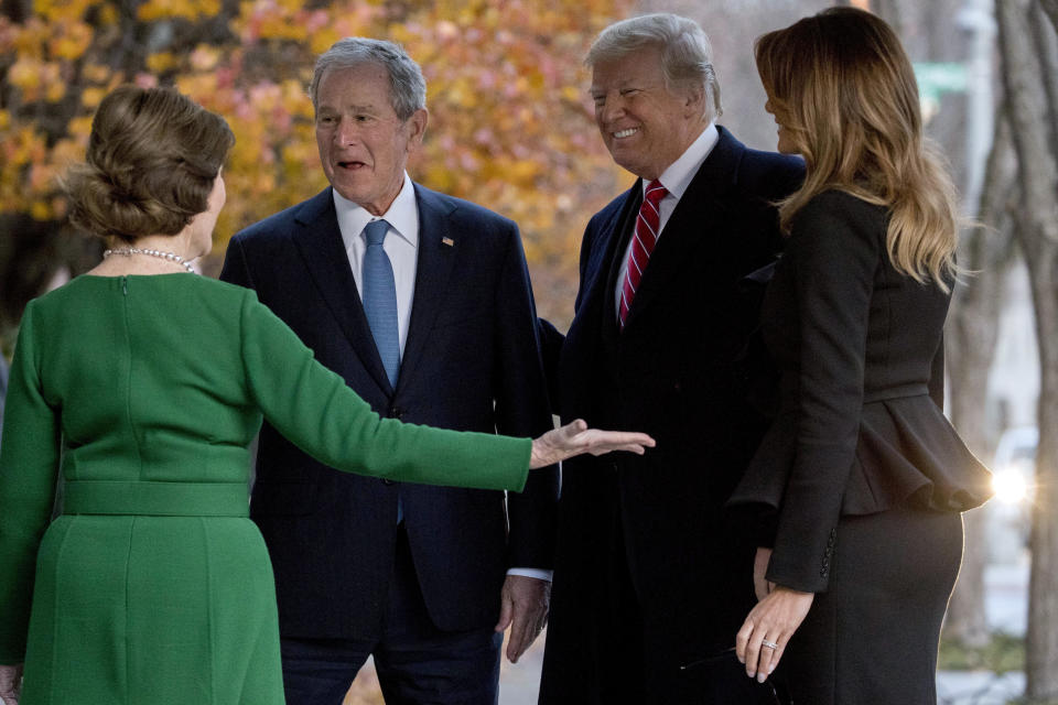 President Donald Trump, second from right, and first lady Melania Trump, right, are greeted by former President George Bush and former first lady Laura Bush outside the Blair House across the street from the White House in Washington, Tuesday, Dec. 4, 2018. (AP Photo/Andrew Harnik)