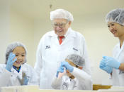 Bei Süßigkeiten sagt der alte Herr wohl nicht Nein. Im Zuge einer Online-Charity-Aktion führte Buffett 2013 eine Familie durch die See’s Candies Firma. (Bild-Copyright: John Shearer/AP)