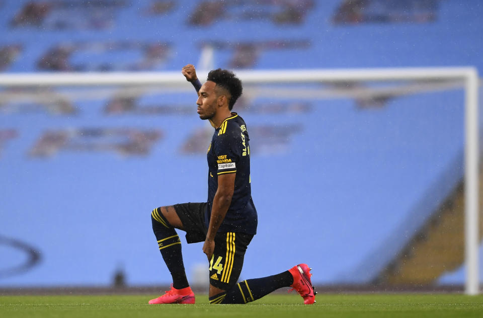 Arsenal's Pierre-Emerick Aubameyang takes a knee in support of the Black Lives Matter movement before the English Premier League soccer match between Manchester City and Arsenal at the Etihad Stadium in Manchester, England, Wednesday, June 17, 2020. The English Premier League resumes Wednesday after its three-month suspension because of the coronavirus outbreak. (Laurence Griffiths/Pool via AP)