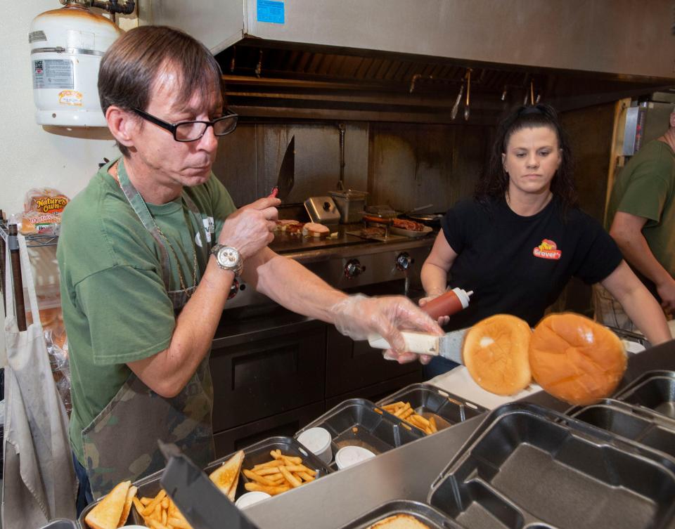 Michael Graham and Amy Johnson work Friday to fill food orders as the lunch rush nears at Grover's Fingers and Wings restaurant on North Davis Highway.