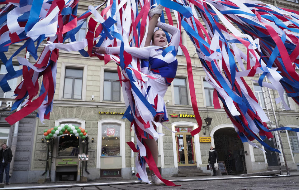 A dancer performs among the ribbons of the colours of the Russian flag during celebration of the anniversary of Crimea annexation from Ukraine in 2014, in St. Petersburg, Russia, Thursday, March 18, 2021. Residents of cities in Crimea and Russia are holding gatherings to commemorate the seventh anniversary of Russia's annexation of the Black Sea peninsula from Ukraine. (AP Photo/Dmitri Lovetsky)