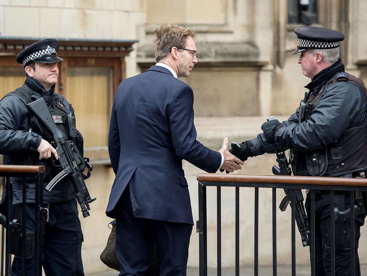 Tobias Ellwood MP shakes hands with an armed policeman as he arrives at the Houses of Parliament: Getty Images