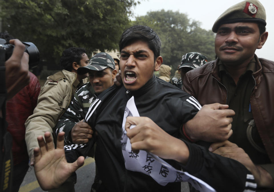 Policemen detain students protesting outside Uttar Pradesh Bhawan during a protest against a new citizenship law and violence by police in the state, in New Delhi, India, Friday, Dec. 27, 2019. The new citizenship law allows Hindus, Christians and other religious minorities who are in India illegally to become citizens if they can show they were persecuted because of their religion in Muslim-majority Bangladesh, Pakistan and Afghanistan. It does not apply to Muslims. (AP Photo/Manish Swarup)