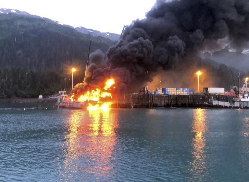 This photo provided by the U.S. Coast Guard shows the fishing boat Alaganik burning at a dock in Whittier, Alaska, in the early morning hours of Monday, July 8, 2019. The Coast Guard says a propane tank exploded around midnight Sunday on the 99-foot (30-meter) fishing vessel at a dock operated by the city of Whittier. The boat burned and sank at the dock. (U.S. Coast Guard via AP)