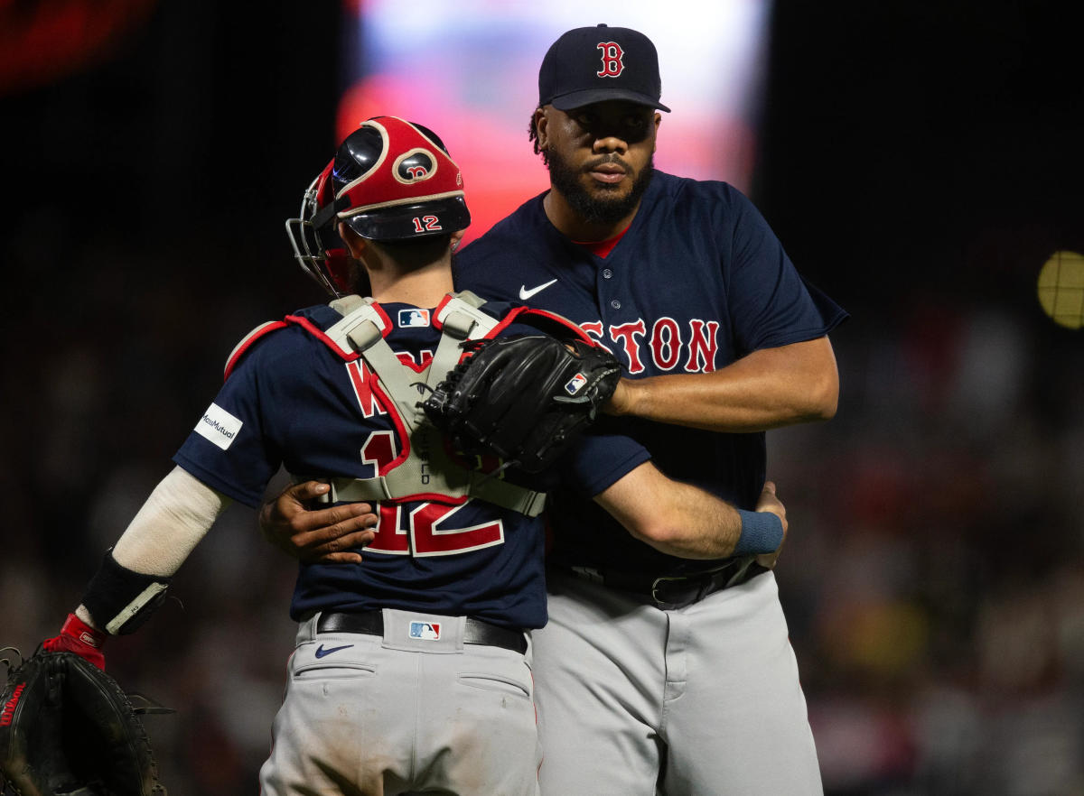 Rafael Devers of the Boston Red Sox poses for a photo with family