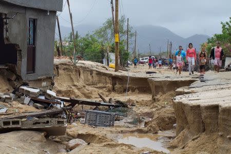 Residents walk along a damaged street in the aftermath of Tropical Storm Lidia in Los Cabos, Mexico, September 1, 2017. REUTERS/Fernando Castillo