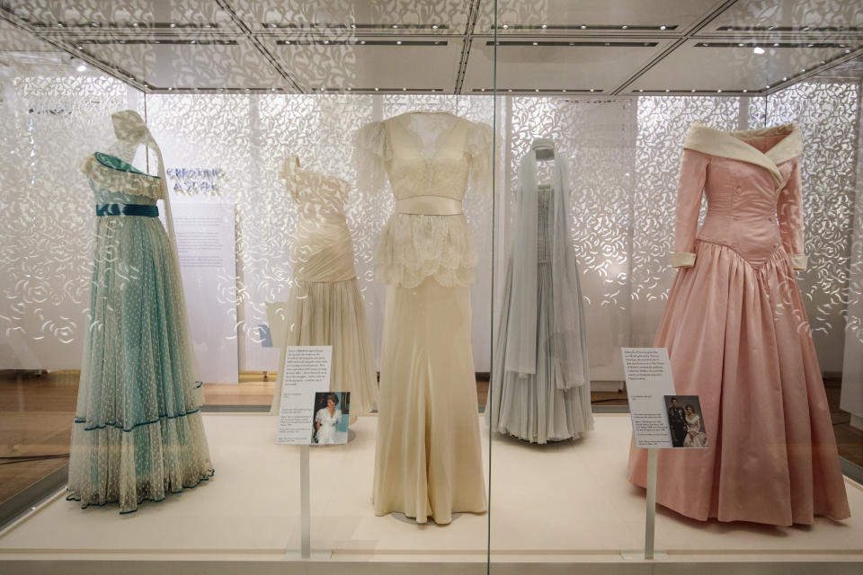 LONDON, ENGLAND - FEBRUARY 22: A 1990 Bruce Oldfield cream satin dress (C) worn by Princess Diana during a visit to the Courtauld Institute of Art in 1990 and a State Banquet at Buckingham Palace in 1991(C) on display next to a 1987 Catherine Walker pink satin evening gown (R) worn by princess Diana for an official portrait in 1987 as well as during official visits to Germany  at a press preview at Kensington Palace on February 22, 2017 in London, England. The exhibition 'Diana: Her Fashion Story', which showcases a number of the Princess' dresses and outfits, opens to the public on February 24 as part of events commemorating the life of Princess Diana to mark the 20th anniversary of her death in Paris on August 31st, 1997.  (Photo by Jack Taylor/Getty Images)