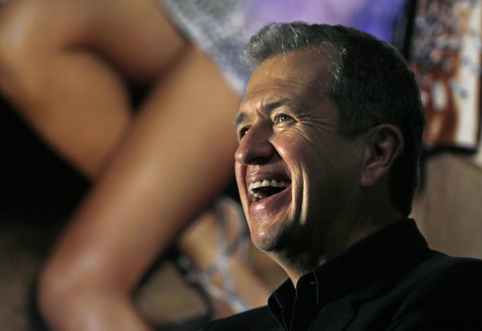 Photographer Mario Testino laughs as he poses for a portrait during the preview of his shows "In Your Face" and "British Royal Portraits" at the Museum of Fine Arts in Boston, Wednesday, Oct. 17, 2012. (AP Photo/Charles Krupa)