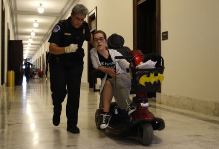 A protester is escorted away by police after being arrested during a demonstration outside Senate Majority Leader Mitch McConnell's constituent office after Senate Republicans unveiled their healthcare bill on Capitol Hill in Washington, U.S., June 22, 2017. REUTERS/Kevin Lamarque