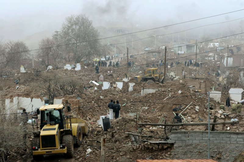 Workers search through the ruins of Zarand, Iran, on February 23, 2005, one day after a devastating earthquake that would go on to kill more than 500 people. UPI File Photo