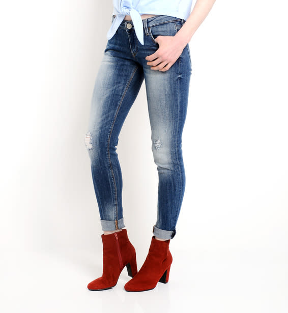 Person in ripped jeans and red ankle boots, paired with a partially tucked-in shirt