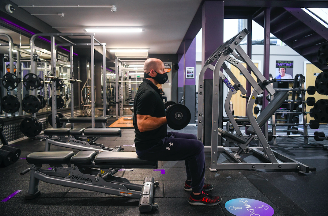 A man wears a face mask as he works out in a gym. (SWNS)