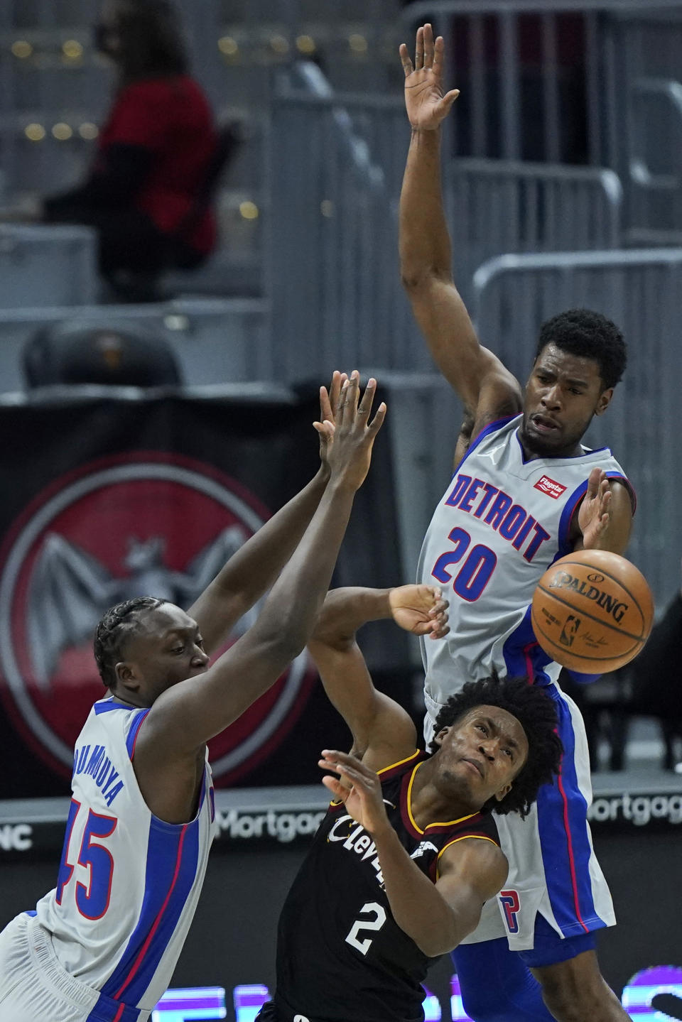 Cleveland Cavaliers' Collin Sexton, center, is stopped by Detroit Pistons' Sekou Doumbouya, left, and Josh Jackson in the second half of an NBA basketball game, Wednesday, Jan. 27, 2021, in Cleveland. The Cavaliers won 122-107. (AP Photo/Tony Dejak)