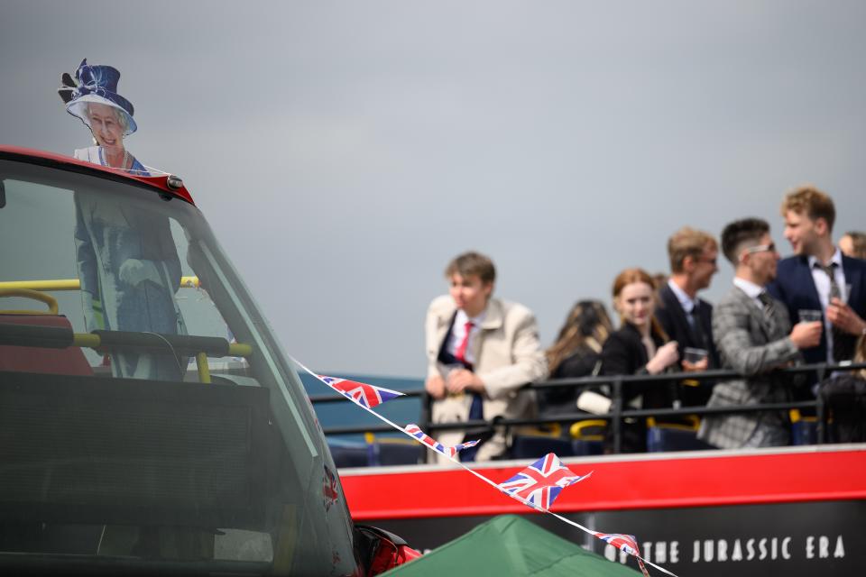 A cardboard cutout depicting Queen Elizabeth II is seen on the top of a decorated bus, as racegoers prepare for the days events (Getty Images)