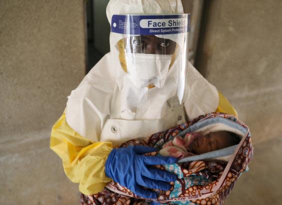 A healthcare worker carries a baby suspected of being infected with Ebola virus in a hospital in Oicha, North Kivu (Reuters)