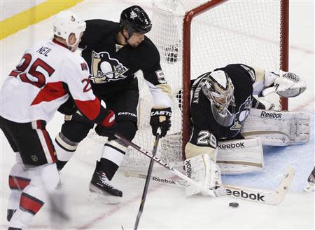 Pittsburgh Penguins goalie Marc-Andre Fleury (29) blocks a shot by Otttawa Senators' Chris Neil (25) as Penguins' Deryk Engelland (5) tries to defend in the third period of their NHL hockey game in Pittsburgh, Pennsylvania, February 13, 2013. REUTERS/Jason Cohn