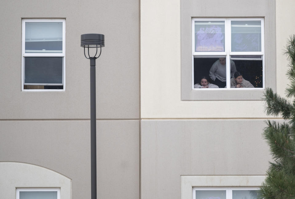 Students look outside their dorm window in the Village at Alpine Valley housing, Friday, Feb. 16, 2024, as police investigate a shooting on the University of Colorado Colorado Springs campus in Colorado Springs, Colo. (Christian Murdock/The Gazette via AP)