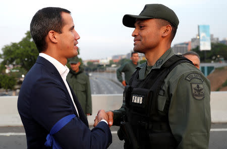Venezuelan opposition leader Juan Guaido, who many nations have recognised as the country's rightful interim ruler, shakes hands with a military member near the Generalisimo Francisco de Miranda Airbase "La Carlota", in Caracas, Venezuela April 30, 2019. REUTERS/Carlos Garcia Rawlins
