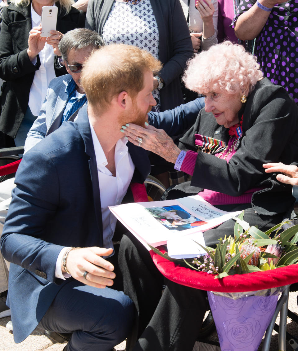 Prince Harry greets royal fan and war widow Daphne Dunne as they arrive for a public walkabout at the Sydney Opera House on Oct. 16, in Sydney, Australia.&nbsp; (Photo: Samir Hussein via Getty Images)