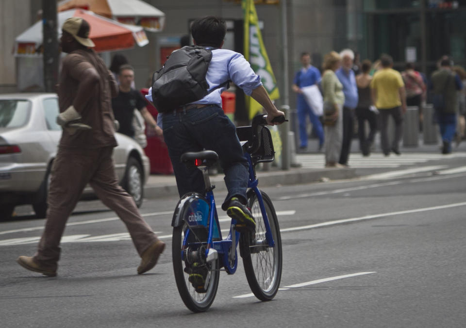 In this Tuesday, June 25, 2013, photo, a biker rides without a helmet on a Citibike, as part of New York City's bike sharing system, in New York. Under Mayor Bloomberg, the city has cracked down on smoking, fatty foods and sugary drinks for health concerns, but the nations largest bike-share program allow riders without helmets. (AP Photo/Bebeto Matthews)